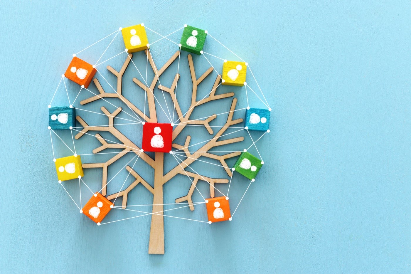Bunte Figuren rund um einen Baum, verbunden wie ein unterstützendes Netzwerk
